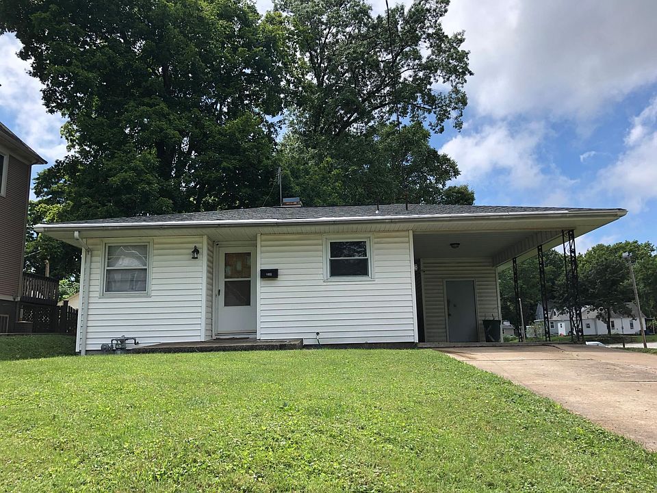 Front of house with car port.