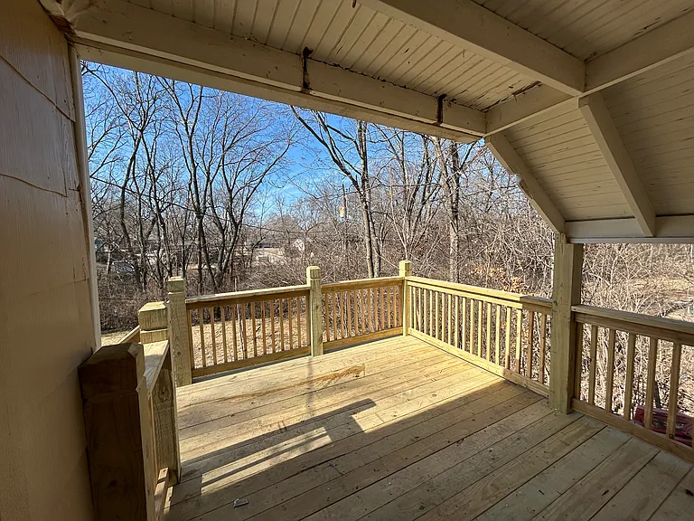 Back deck is partially covered with a great view of yard and woods.