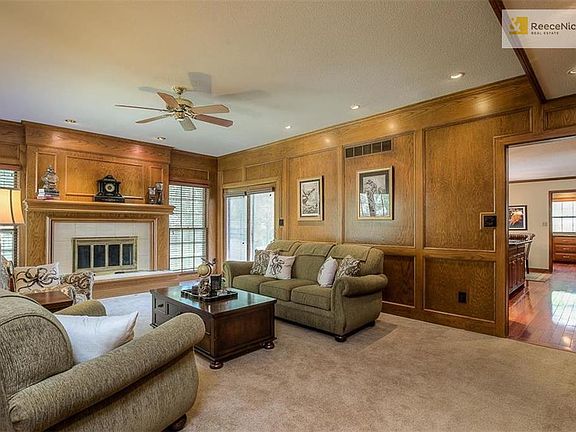 Great Room features library paneling, fireplace and windows overlooking backyard.