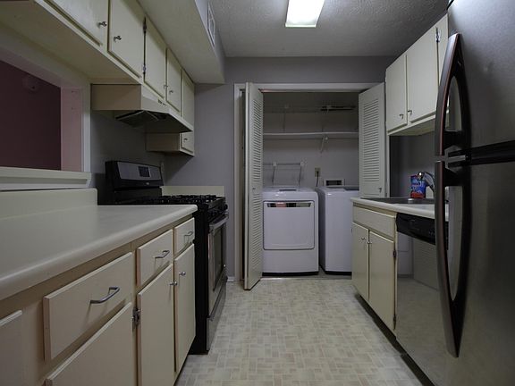 Kitchen with Stainless Steel appliance and washer dryer clos