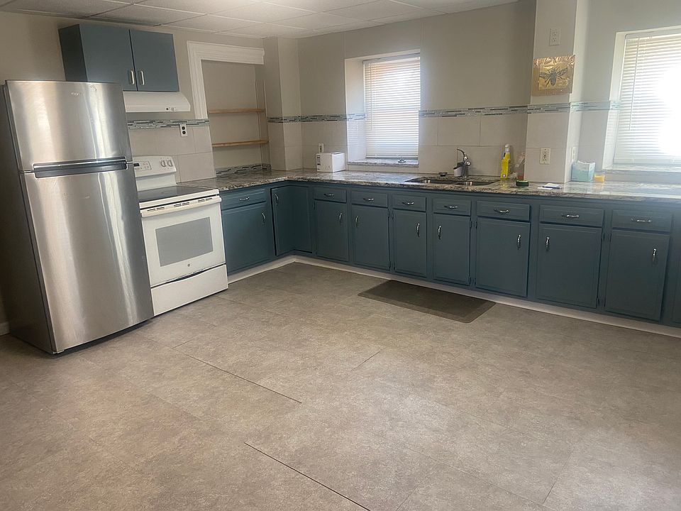 Kitchen with refrigerator, stove and large pantry area.