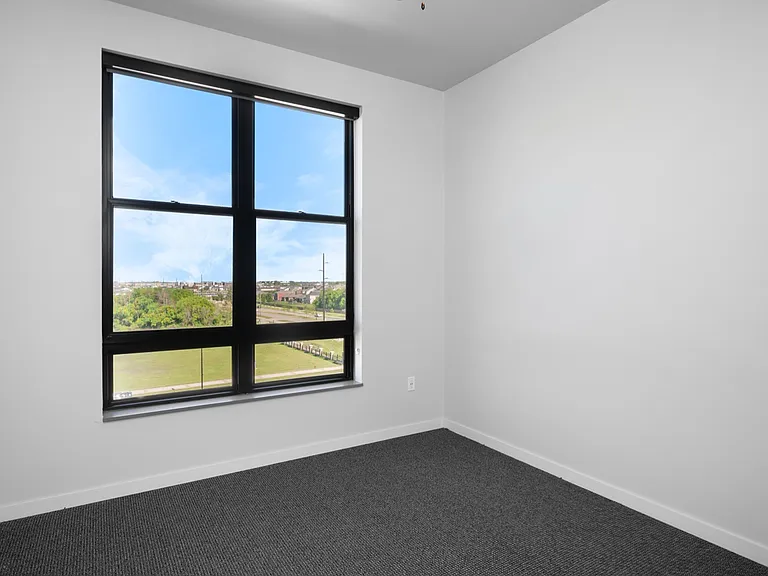 Bright room with a large window offering stunning views of greenery and cityscape, perfect for a cozy home office or bedroom. Bright room with a large window offering stunning views of greenery and cityscape, perfect for a cozy home office or bedroom.