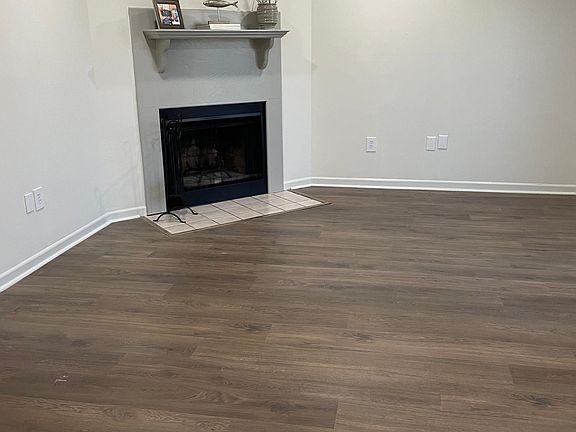 Living area with fireplace. Wood flooring has been replaced with new lighter colored flooring.
