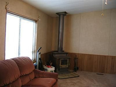Large Living Room With Wood Stove, Paddle Fan,and New Carpet