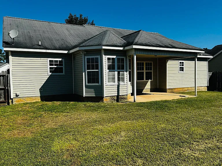 Rear exterior view showcasing the cozy covered patio perfect for outdoor relaxation.