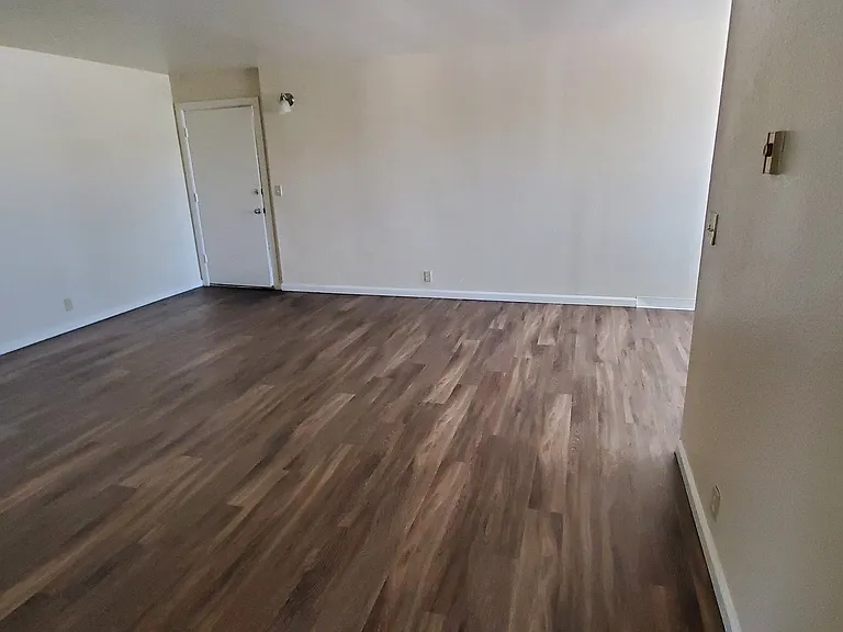 Front room with hardwood flooring at Zenith Place Apartments in Chula Vista, California.