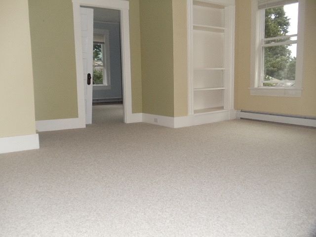 Living room looking east into bedroom. Shelving unit has cable so a TV can be placed in cabinet.