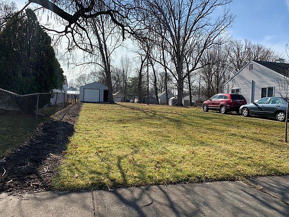 Side view of the property, with a flower bed leading to the shed.