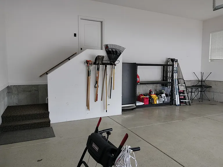 The property includes a two-car garage with extra storage racks, an outdoor freezer, and a 220V plug for convenient electric vehicle charging. Perfect for secure parking and additional storage needs.
