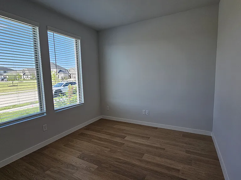 Bright and private home office featuring large windows for plenty of natural light_an ideal setup for remote work.