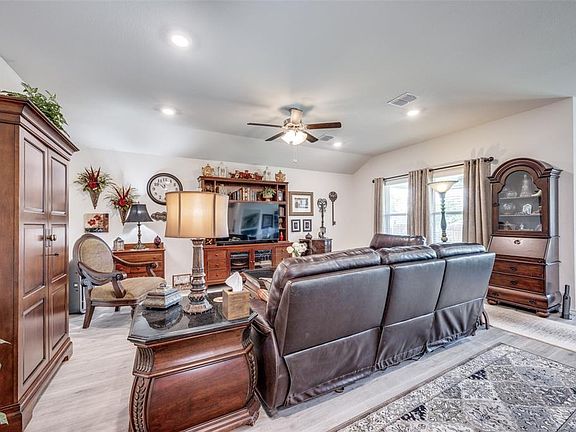 Living room with ceiling fan, light wood-style flooring, recessed lighting, and vaulted ceiling