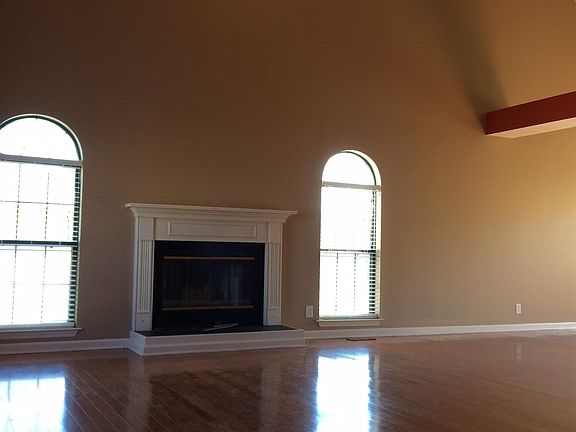 Living room with vaulted ceiling and a fireplace.