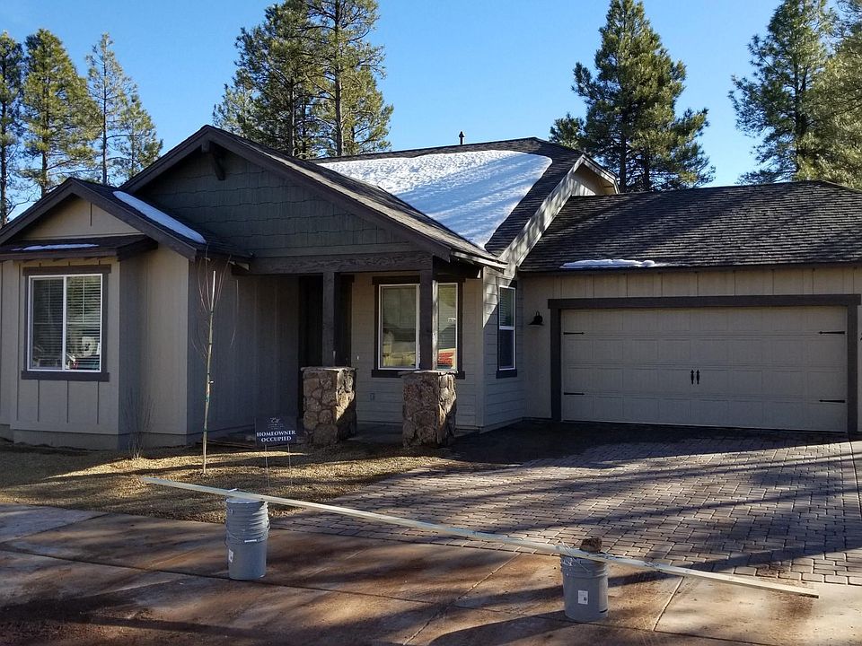Front of home with paver driveway and drip irrigation landscaping