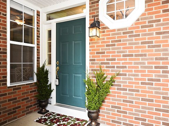Private Entry with Room for a Small Table. Nice Entry Exterior Design. Octagon Window, Side Corner Window and Transom Windows Line the Doorway.
