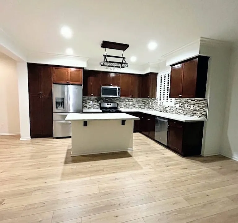 Another view of the kitchen from the open-concept living room point of view (virtually staged to reflect updated flooring)