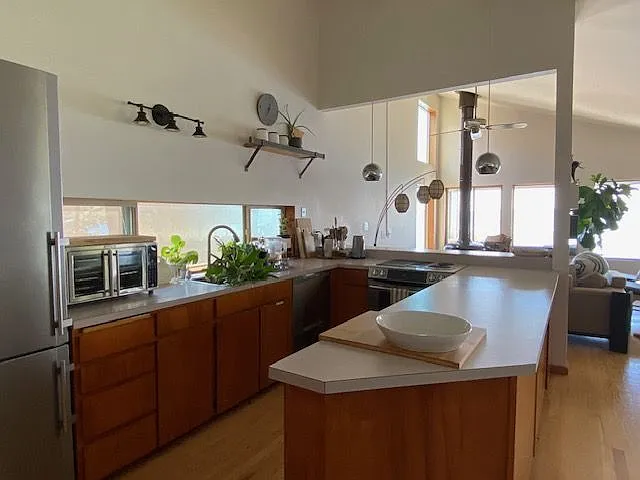 Kitchen area, stainless steel appliances, high ceilings and an open concept.