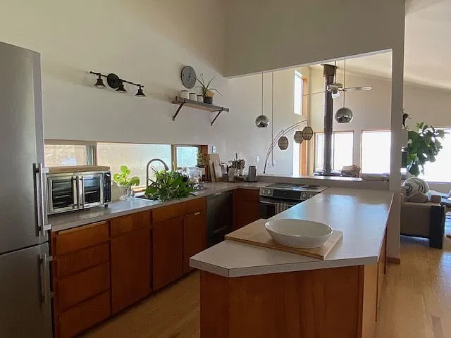 Kitchen area, stainless steel appliances, high ceilings and an open concept.