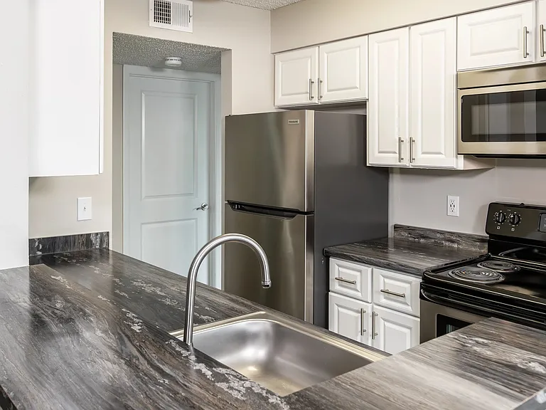 Craft your mornings in gourmet style with a kitchen offering a breakfast bar view of stainless-steel allure and modern granite-inspired countertopsa perfect fusion of style and functionality.