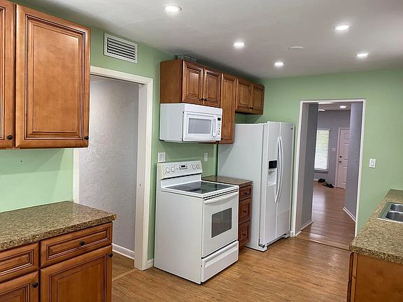 kitchen with entrance on left to hallway/ living room and door to right is dining room
