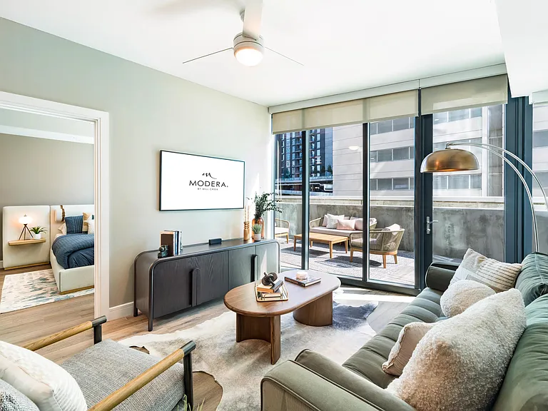 An airy living room at Modera McGavock, opening to a private terrace and city views, with Nashville's dining and entertainment close at hand.