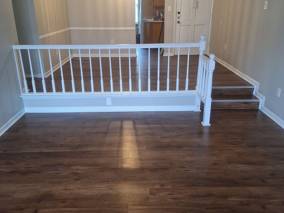 View from patio door in living room with dining area and kitchen entry. Note the chandelier and LV flooring..