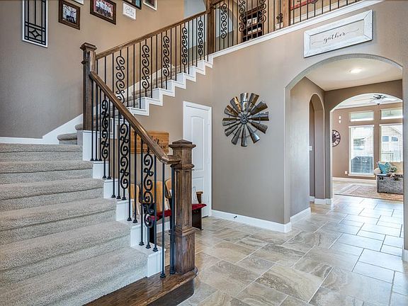 Open the door to this warm and welcoming home! A wrought iron and wood staircase leads to the upstairs living spaces!