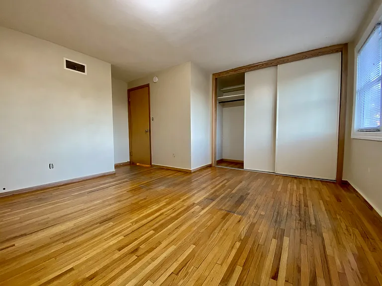 Bright and spacious bedroom with hardwood floors and large closet, featuring ample natural light from the window. Bright and spacious bedroom with hardwood floors and large closet, featuring ample natural light from the window.