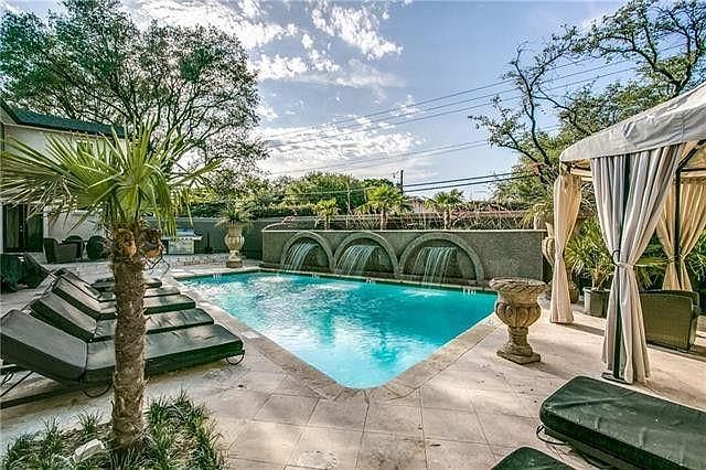 Pool with fountains and lounge chairs and gazebo.