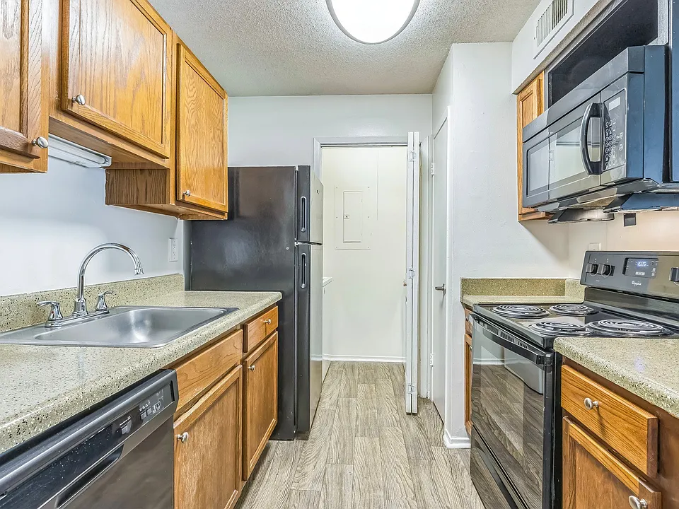 Well-appointed kitchens feature wood cabinetry and sleek black appliances for everyday convenience, professionally operated by Highlands Vista Group.