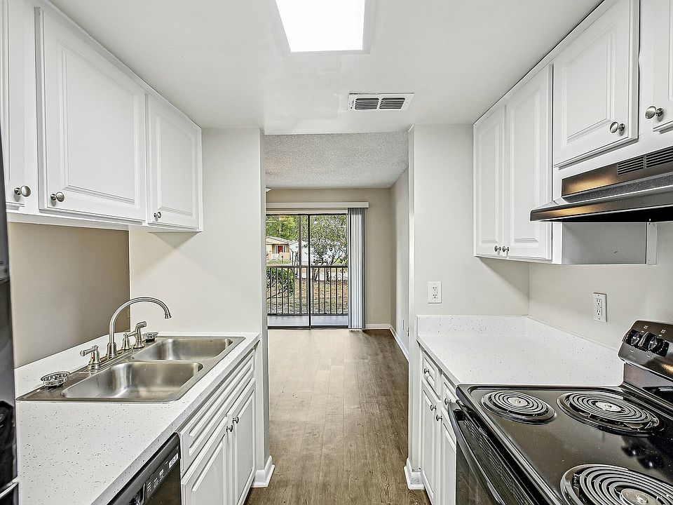 Galley-style kitchen with bright finishes and balcony view.