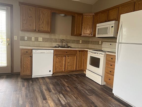 Kitchen with full appliances, with door to back patio area.