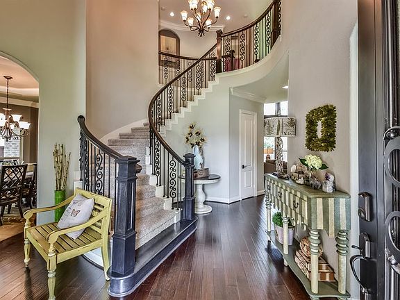 Beautiful entrance and Stairway showing the beautiful hardwood floors tile and iron railings