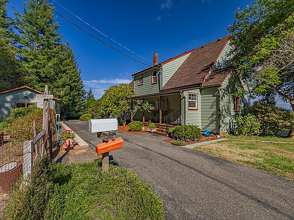 Northwest side of the house features the porch for the rear entry into the large laundry/mudroom. The exposure provides plenty of light for the raised bed garden, which includes a well-established asparagus bed.
