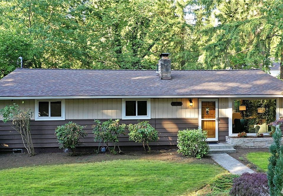 Front of home surround green lush trees.
