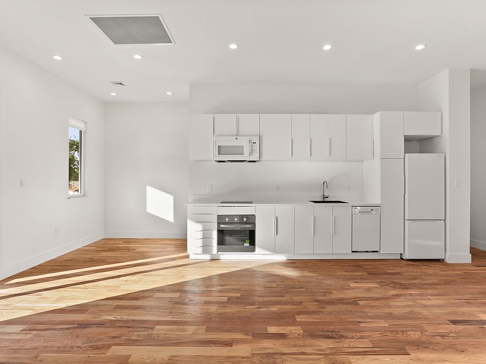 Full kitchen with modern appliances, dining table nook on the left.