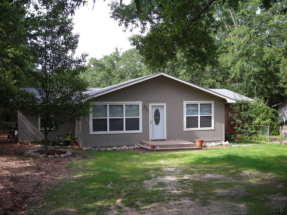House sits on front half of 1 acre, fenced in lot. Landscaped beds. 