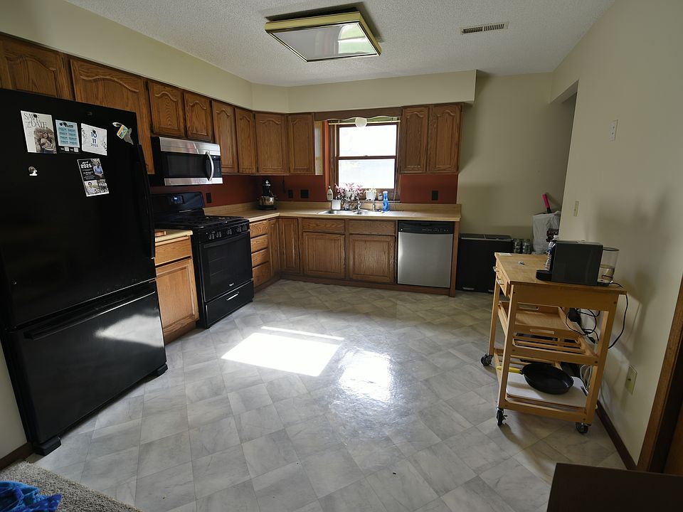 Large 12' x 12' kitchen with bottom-freezer fridge, above-range microwave, 5-burner gas stove, and dishwasher.