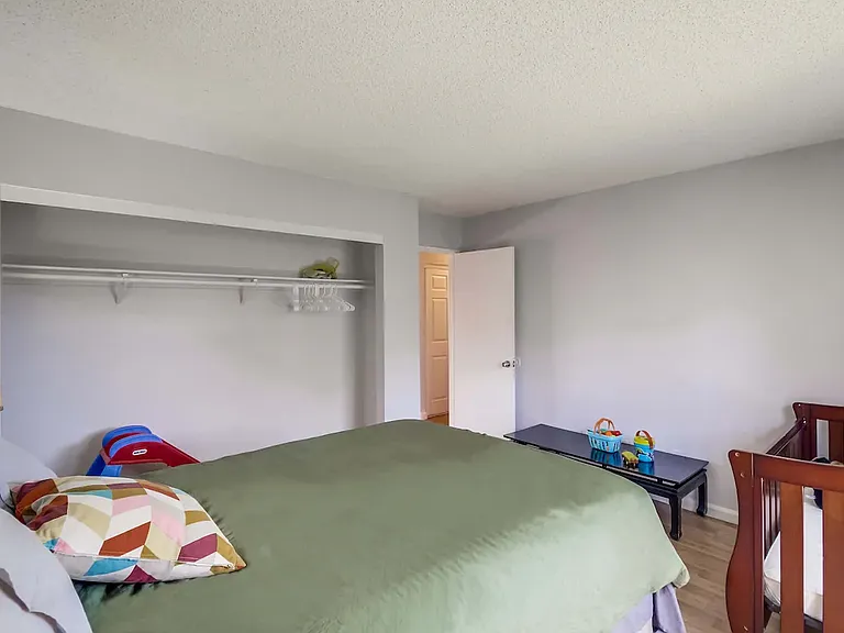 Bedroom 2 with queen bed, en-suite bathroom, and crib for your little one.