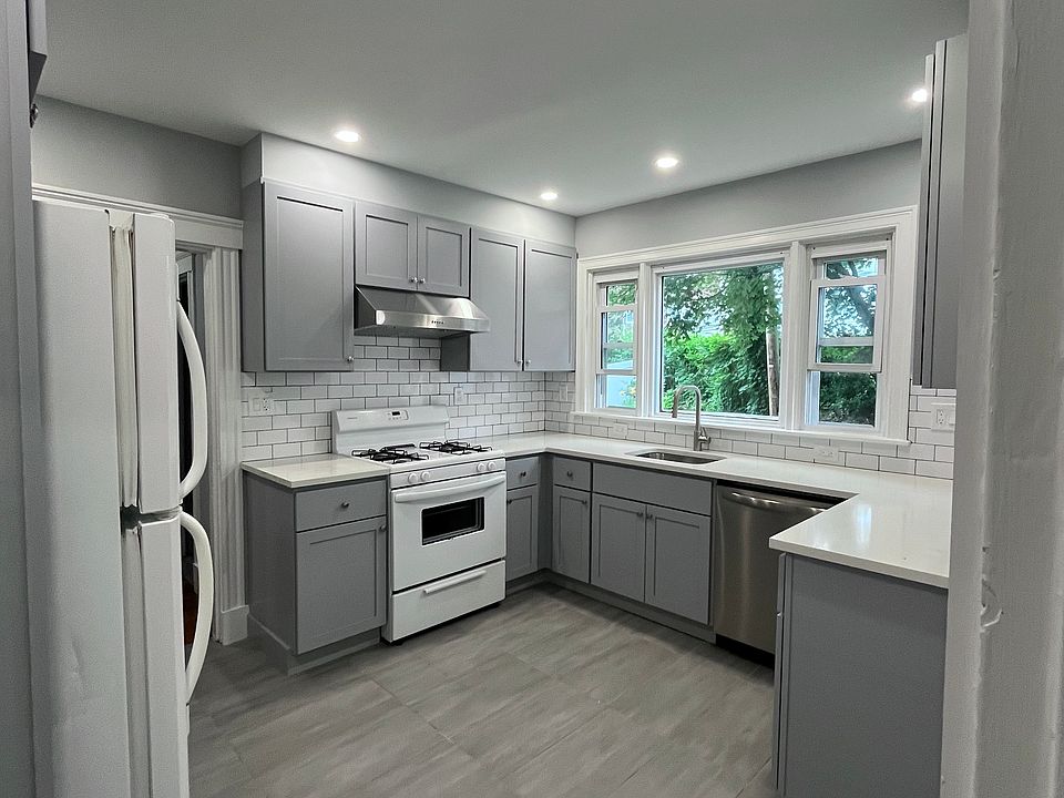 Newly renovated kitchen with new kitchen cabinets, quartz countertops, tile floors and backsplash, new electrical work and plumbing, and recessed lighting