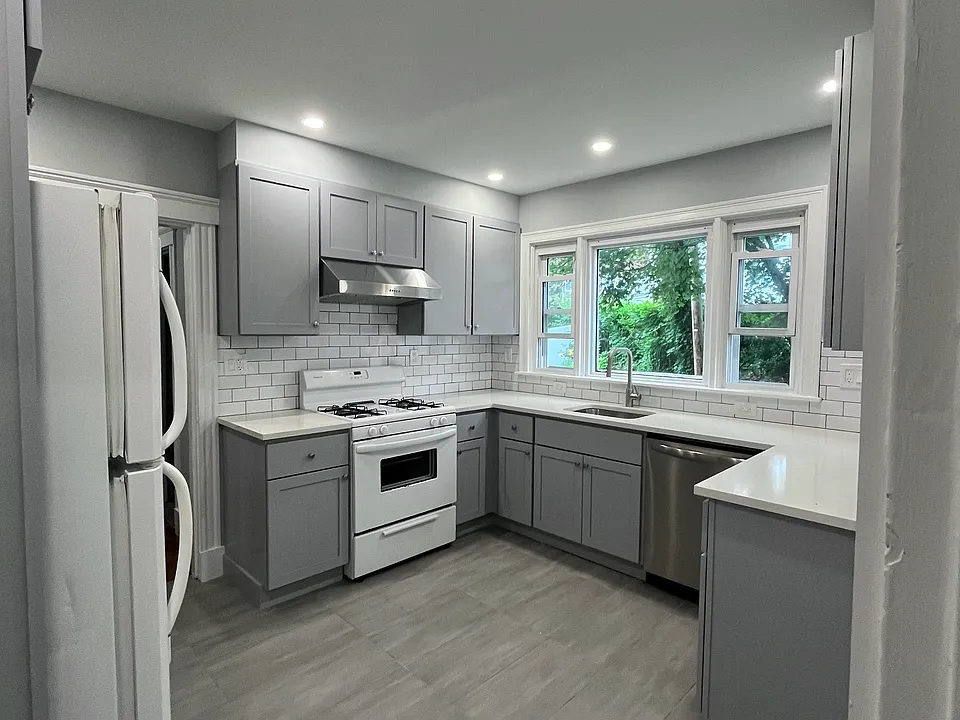 Newly renovated kitchen with new kitchen cabinets, quartz countertops, tile floors and backsplash, new electrical work and plumbing, and recessed lighting