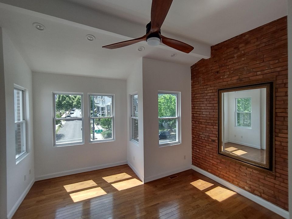 Primary Bedroom
Expansive primary bedroom featuring five large windows that flood the space with natural sunlight, complemented by high ceilings, rich wood floors, exposed brick accents, and a striking vintage mirror _ full of warmth and character. ______