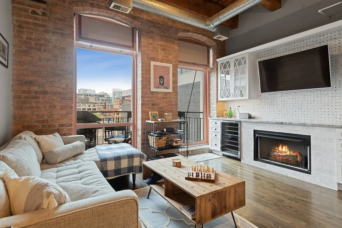 Beautiful living space with natural light and a cozy fireplace. - 360 W Illinois St #410