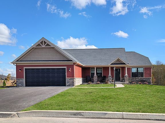Red ranch-style Coleford home plan with stone accents, covered front porch, black garage door, and g