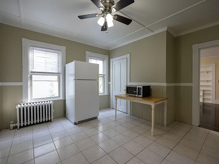 Large eat-in kitchen with refrigerator, ample cabinet space, and ceiling fan