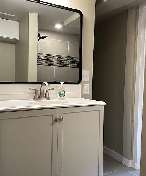 Wide vanity with large cabinet below sink.