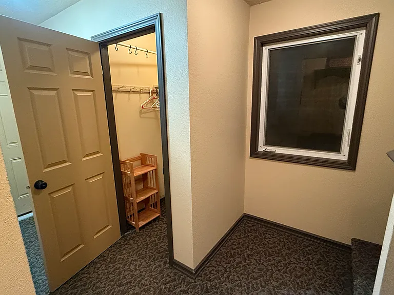 Hall outside of condo with storage closet.