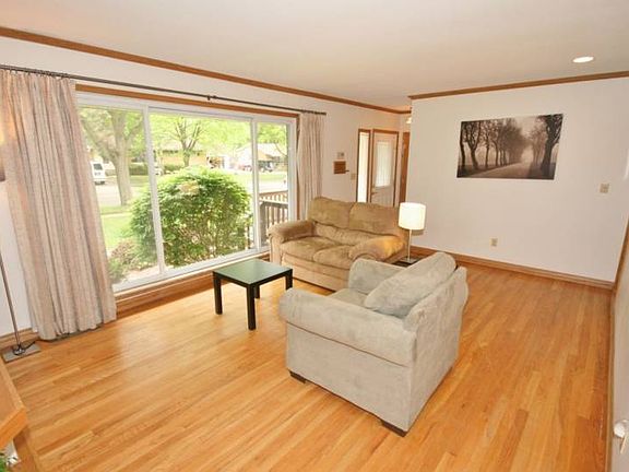 Huge floor to vinyl ceiling windows highlight the gorgeous wood floors and are trimmed by ceiling crown molding.