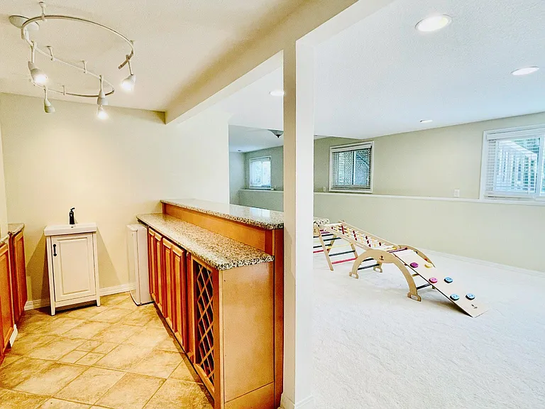 Basement Wet Bar with High-end Wood Cabinets and Granite Countertop.