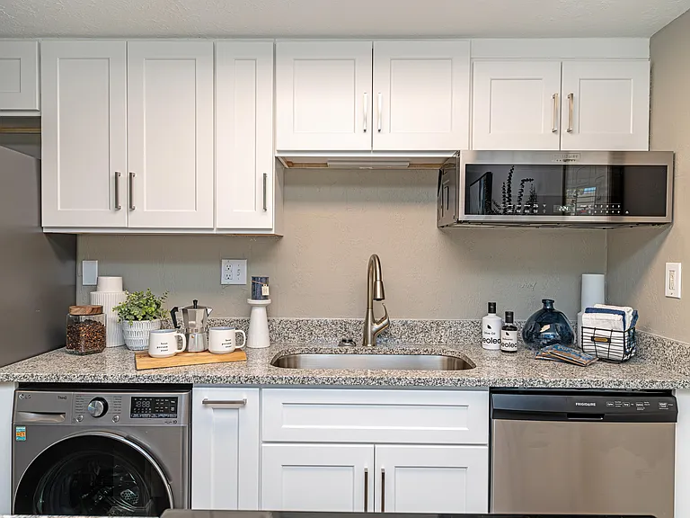 Kitchen with granite counters, modern cabinetry, & hardwood-style flooring