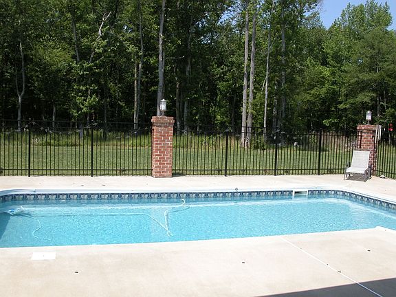 Cool, refreshing pool in back with iron fence